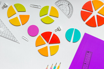 Wall Mural - Background of wooden pie charts. Multicolored math fractions, rulers, pencils on white background. Interesting, fun math for kids. Education, back to school concept