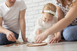 © satura_ - Baby child with hearing aids and cochlear implants plays with parents on floor. Deaf and rehabilitation concept