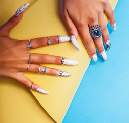 Wall Mural - woman hands holding colorful paper copyspace wearing a lot of jewelry and long nails