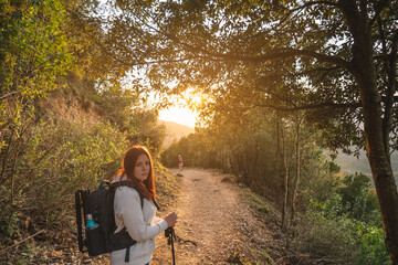 young hiker, looking at the camera, watching the sunset on the mountain. concept of the hobby and travel. copy space