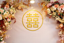 Chinese Wedding Symbol Paper Cut And Flowers Decorated On The Wall. Chinese Wedding With "Double Happiness" Text Calligraphy Illustration On Paper Cut Design.
