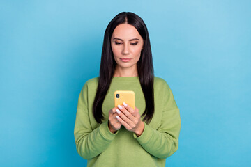 Poster - Portrait of calm serious girl hols use telephone typing comment isolated on blue color background