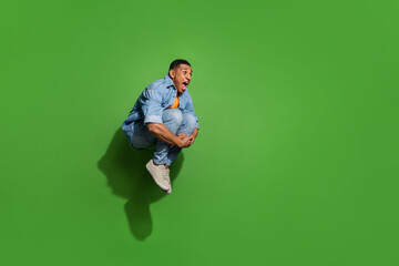 Wall Mural - Full length photo of attractive overjoyed screaming man have fun jumping into water pool isolated on green color background