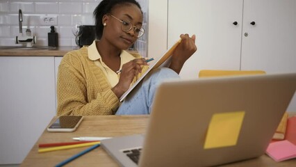 Wall Mural - Young African American woman learning from her living room.