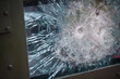 Detail with bullet gun shots through a armored window of a military vehicle