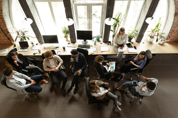 Wall Mural - Working process at modern business company. Young men and women discussing something with coworkers, sitting at office table. Concept of team, job, career