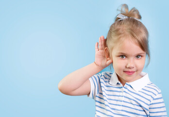 Child with hearing problem on blue background empty copy space. Hearing loss, symptoms and treatment concept.