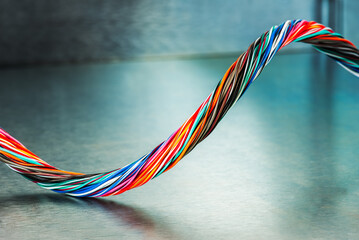 Wall Mural - Swirl of multicolored electrical computer cable on metallic background