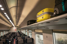 Suitcases lying in the cabin of the train in places for the handle luggage. Travelling in Europe by train, euro-trek, luggage rack. High quality photo