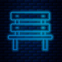 Poster - Glowing neon line Bench icon isolated on brick wall background. Vector