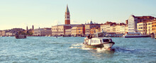Italy, Venice, Panoramic Image Of Riva Degli Schiavoni, The Venice Promenade, With Passenger Boats. City Skyline Banner. Church Santa Maria Della Salute, Doge's Palace And St Mark's Campanile.