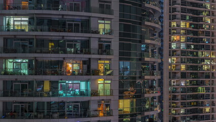 Flat night panorama of multicolor light in windows of multistory buildings aerial timelapse.