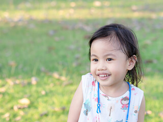 Wall Mural - Positive charming 4 years old cute baby Asian girl, little preschooler child smiling and looking to the left