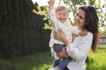 Wall Mural - Happy mother with her cute baby in park on sunny day, space for text