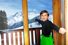 Boy In Ski Outfit Open The Door To Mountain Peaks Panorama