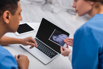 Wall Mural - Blurred multiethnic veterinarians working with ultrasound scan of animal in clinic