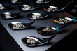 Black caviar on black spoons. Luxurious buffet table.