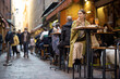 © rh2010 - Woman sitting on crowded street at bar or restaurant outdoors in Bologna city. Concept of Italian lifestyle and gastronomy