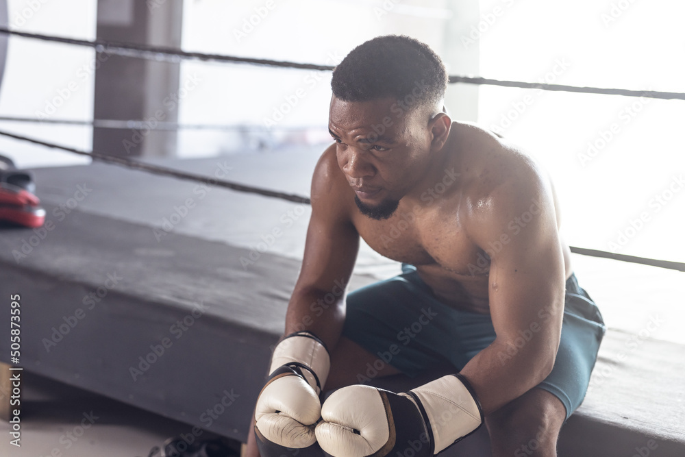 Shirtless tired african american young male boxer contemplating while ...