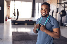 Portrait Of Smiling African American Young Male Boxer With Skipping Rope Around Neck In Health Club