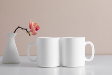 Two White Coffee Mug Mockup With Orchid Flower Pink. Empty Cup Mock Up For Design. Front View.