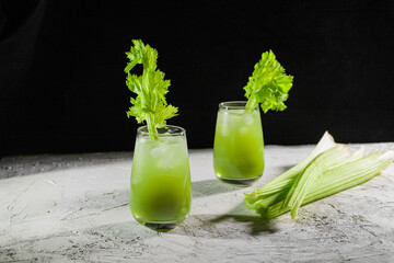 Wall Mural - celery juice in glass on black background