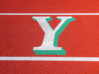 Wall Mural - Two tone white and green letter Y painted on running track.