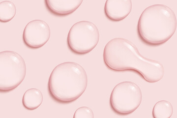 Drops of cosmetic liquid on pink background.