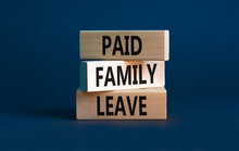 Paid family leave symbol. Concept words Paid family leave on wooden blocks. Beautiful grey table grey background. Business medical and paid family leave concept. Copy space.