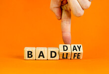 Bad day or life symbol. Businessman turns wooden cubes and changes concept words Bad life to Bad day. Beautiful orange table orange background. Business and bad day or life concept. Copy space.