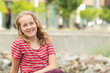 © snesivan - Portrait of a little cheerful girl in a striped T-shirt.