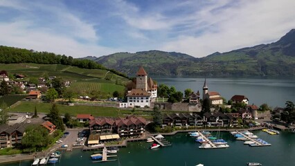 Wall Mural -  lake Thun and the Spiez village aerial drone footage with medieval castle and old town in the alps in Canton Bern in Switzerland