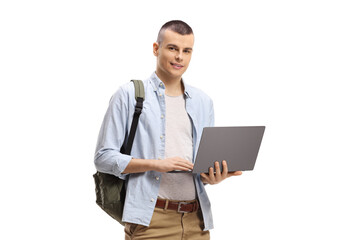 Smiling male student standing and using a laptop computer