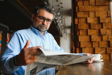 Newspaper in the morning. Senior businessman at his office riding newspapers.