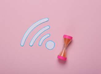 Wi-fi Waves icon and hourglass on pink background. Top view