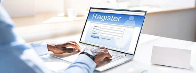 Businessman's Hand Filing Online Registration Form On Laptop