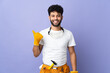 Young electrician Moroccan man isolated on purple background pointing to the side to present a product