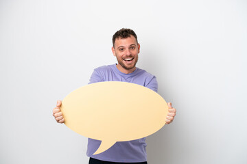 Wall Mural - Young Brazilian man isolated on white background holding an empty speech bubble