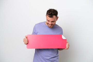 Wall Mural - Young Brazilian man isolated on white background holding an empty placard