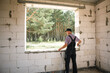 © Ольга Симонова - Construction worker at construction site measures the length of window opening and brick wall with tape measure. Cottage are made of porous concrete blocks, work clothes - jumpsuit and baseball cap