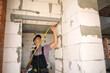 © Ольга Симонова - Construction worker at construction site measures the length of window opening and brick wall with tape measure. Cottage are made of porous concrete blocks, work clothes - jumpsuit and baseball cap