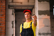 © Ольга Симонова - Construction and finishing worker holds out key to the house. Turnkey construction, repair, relocation, mortgage. Engineer in protective workwear jumpsuit and cap