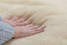 Woman Spreads A Blanket Of Natural Sheep Fur