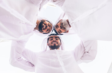 Wall Mural - Three business men walking in Dubai wearing traditional emirati clothes