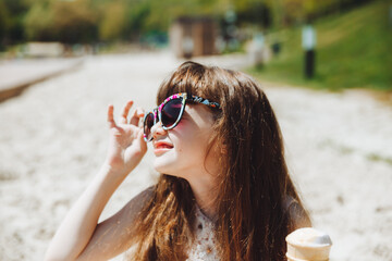 Happy little girl eating ice cream on the beach in summer. summer vacation