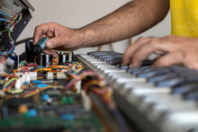 Latin American Electronic Technician Hands Checking The Operation Of The Circuit Of An Electric Piano In The Service Center. Concept Repair, Music, Electronic