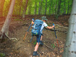 © Daniel CHETRONI - Happy boy with backpack and trekking sticks hiking in mountain forest