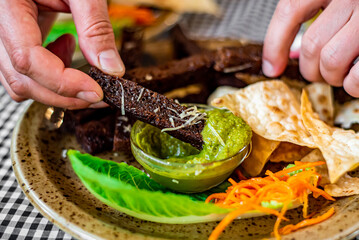 man hand and plate with snacks on table background on bar or pub