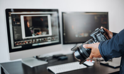 photographer hand camera and computer on desk