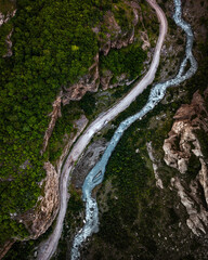 Wall Mural - Top view of mountain road in forest with blue river